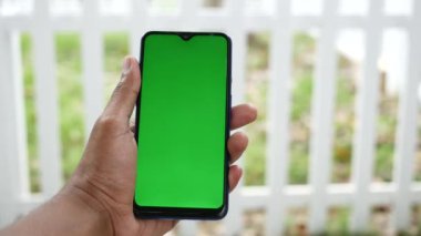 Açık havada akıllı telefon kullanan genç bir adamın dikiz görüntüsü .