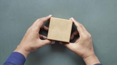 men hand pick candy from a box on table ,