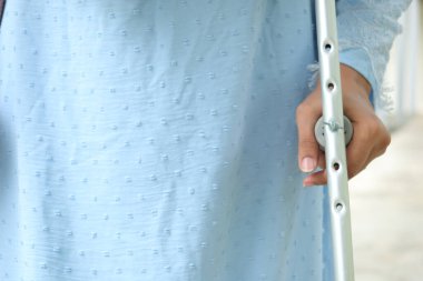 Koltuk değnekleriyle kırık bacaklı genç kadınlar.