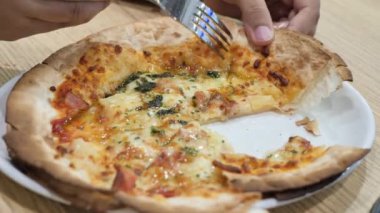 Tahta masadaki bir tabakta peynirli pizza.