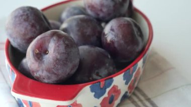 stack of plums in a bowl on white background ,