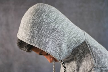 Kapüşonlu üzgün adam elleri siyah kaplı.