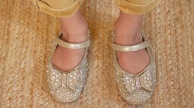 child with sandal moving her feet .