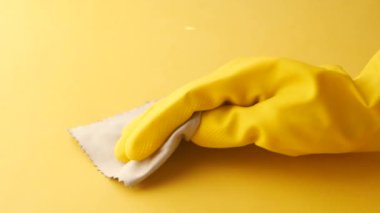 Sarı lastik eldivenlerle kaplı masayı temizleyin. .