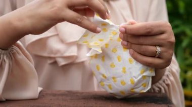 women open a burger paper packet outdoor ,