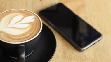 Kafenin tepesinde çiçek desenli geç kalmış bir fincan kahve. .