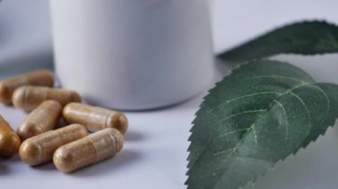 Beyaz üzerine düşen bitkisel ilaç kapsülü .