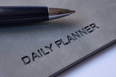  daily planner and a pen on table .