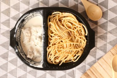 top view of pasta in a take away container .