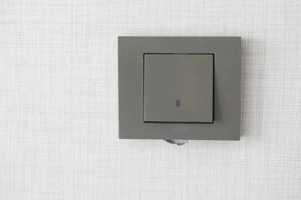 stock image  a lighting switch against white wall .