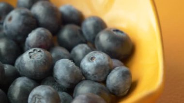 Taze böğürtlen meyvesini portakal renkli bir kaseyle masanın üzerine koy. ,