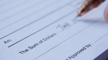  A man writes payment due in a paper form .