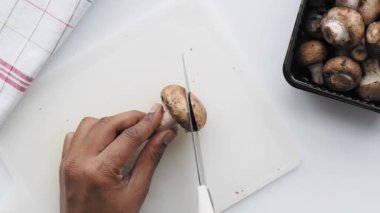 Taze şampiyon mantarını doğrama tahtasıyla kesiyorum. .