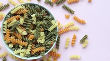 Pembe arka planda organik fusilli üç renkli döküntü .