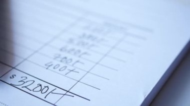  A man writes payment due in a paper form .
