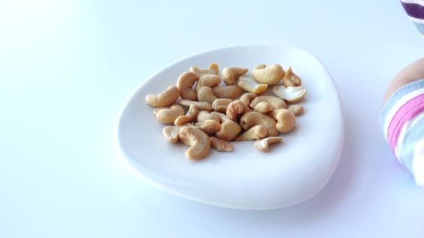 Child Hand Picks Cashew Nuts Table — Stock Video