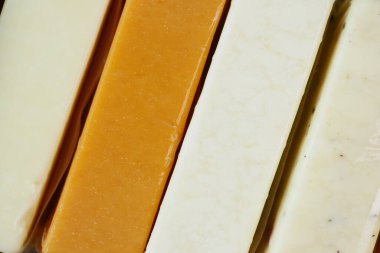 Cheese cubes green, yellow and red color on chopping board .