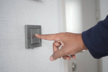 Işık düğmesini açan bir parmak