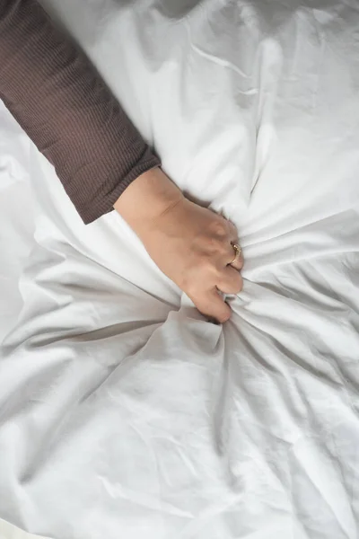 hand of women pulling white sheets i