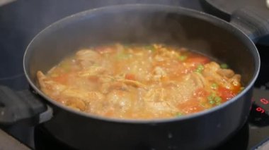 Tavada körili tavuk pişirmek. ,