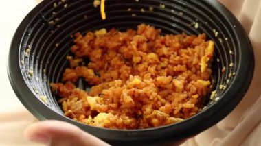 Plastik kasede tavuk pilavı yemek. ,