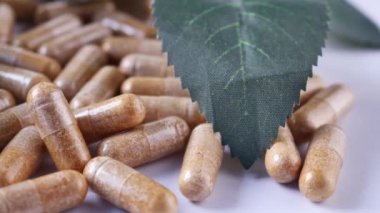 Bitkisel ilaç kapsülü ve beyaz yaprak. .