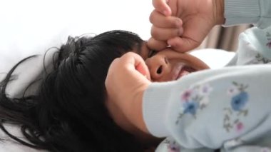 a upset child girl cover her face with hand .