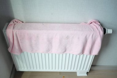  Isıtma radyatöründe sarı renkli havlu kurutuluyor