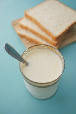 Masadaki bir bardak süt ve kaşığı kapat. .