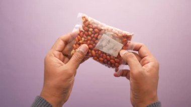 Elinde bir paket fıstık tutan adamlar. ,