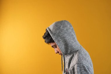 Başlıklı üzgün adam yüzünü gizliyor. .