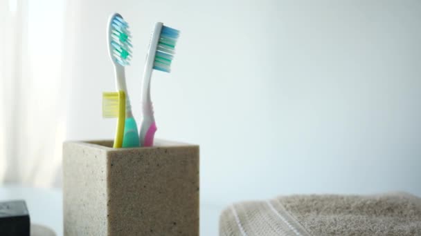 Kleurrijke Tandenborstels Witte Mok Tegen Een Muur — Stockvideo