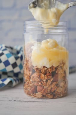  putting yogurt in granola Musli in a bowl