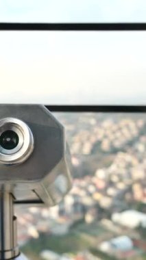 Şehir binalarını gözetleyen madeni paralı dürbünler.