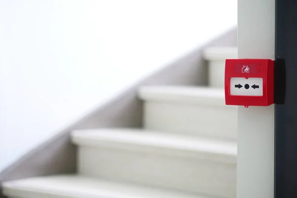 Red fire alarm button on wall