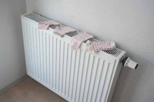 采暖散热器上的儿童袜子烘干 — 图库照片