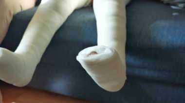 Bacağında yara bandı olan küçük bir çocuk.