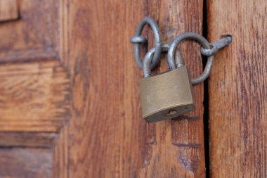Ahşap bir kapı kapalı eski paslı kilit.