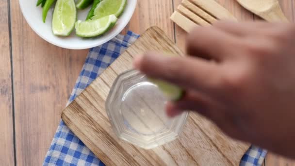 テーブルの上でレモンの水を飲む 上のビューをリフレッシュ — ストック動画