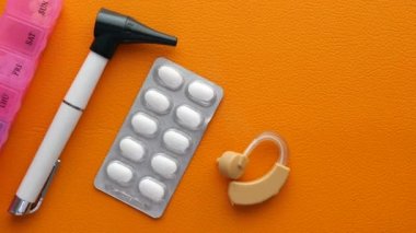 İşitme cihazı ve tıbbi ilaçlar masada. ,