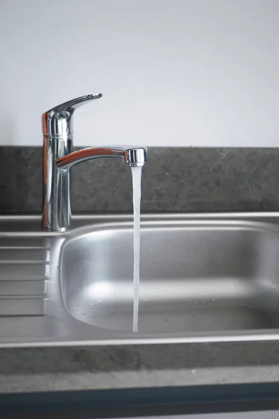 stock image water pouring from a faucet tap slow motion .