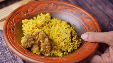 boiled yellow rice with meats on a plate .