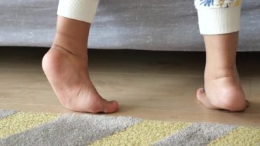 Parmak uçlarında yürüyen bir çocuğun düşük açılı görüntüsü.