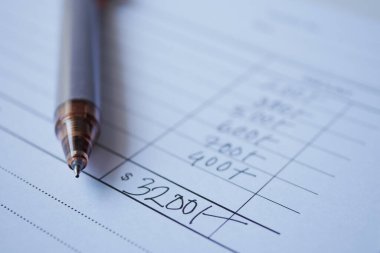  A man writes payment due in a paper form .