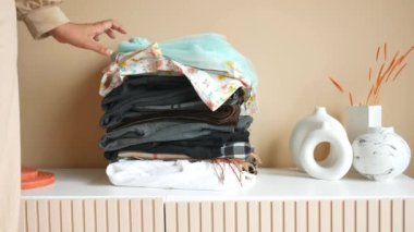 İçerideki masada yığınla kıyafet var.