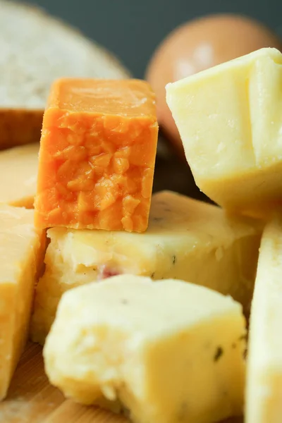 切碎板上的奶酪方块呈绿色 黄色和红色 — 图库照片