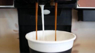 Kahve makinesinden kahve dökülüyor. .