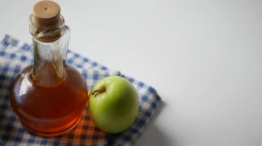Cam şişede elma sirkesi ve masada taze yeşil elma. ,