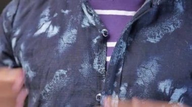 Adam gömleğini ilikliyor..