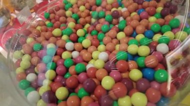 Çok sayıda yuvarlak şekeri alışveriş merkezindeki cam bir kavanozda çok renkli şekerlemelerle yakın çekim yapın. ,